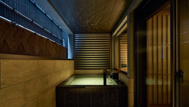 A modern bathroom with a stone sink, a bathtub, and a sliding glass door. - Gion Kuromatsu (Kyoto)