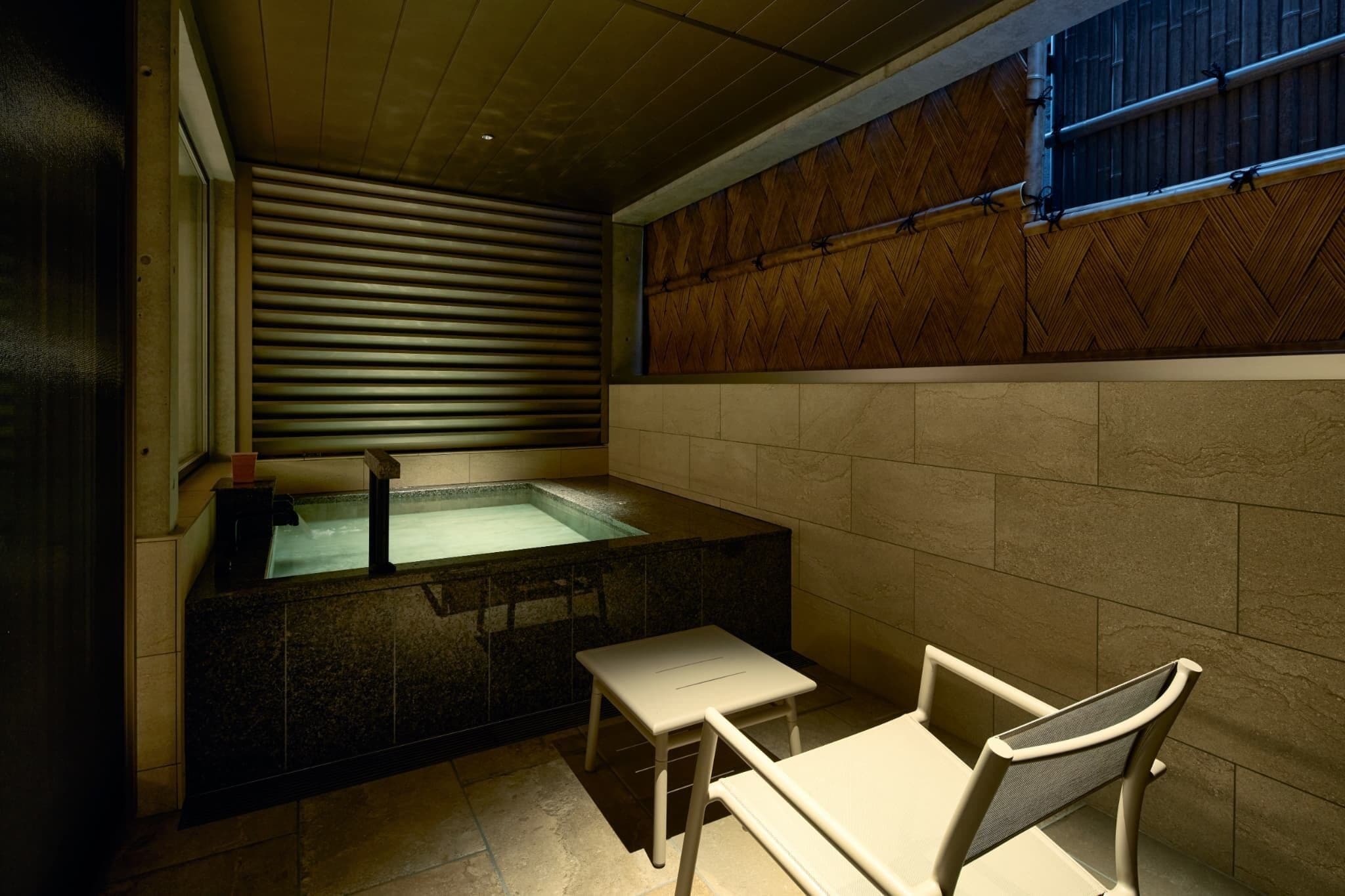 Un área de spa con un jacuzzi, una mesita y sillas.
