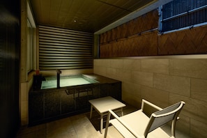 A spa area with a hot tub, a small table, and chairs. - Gion Kuromatsu (Kyoto)