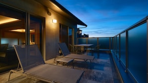 A rooftop terrace with sun loungers, a table, and a view of the sky. - Gion Kuromatsu (Kyoto)