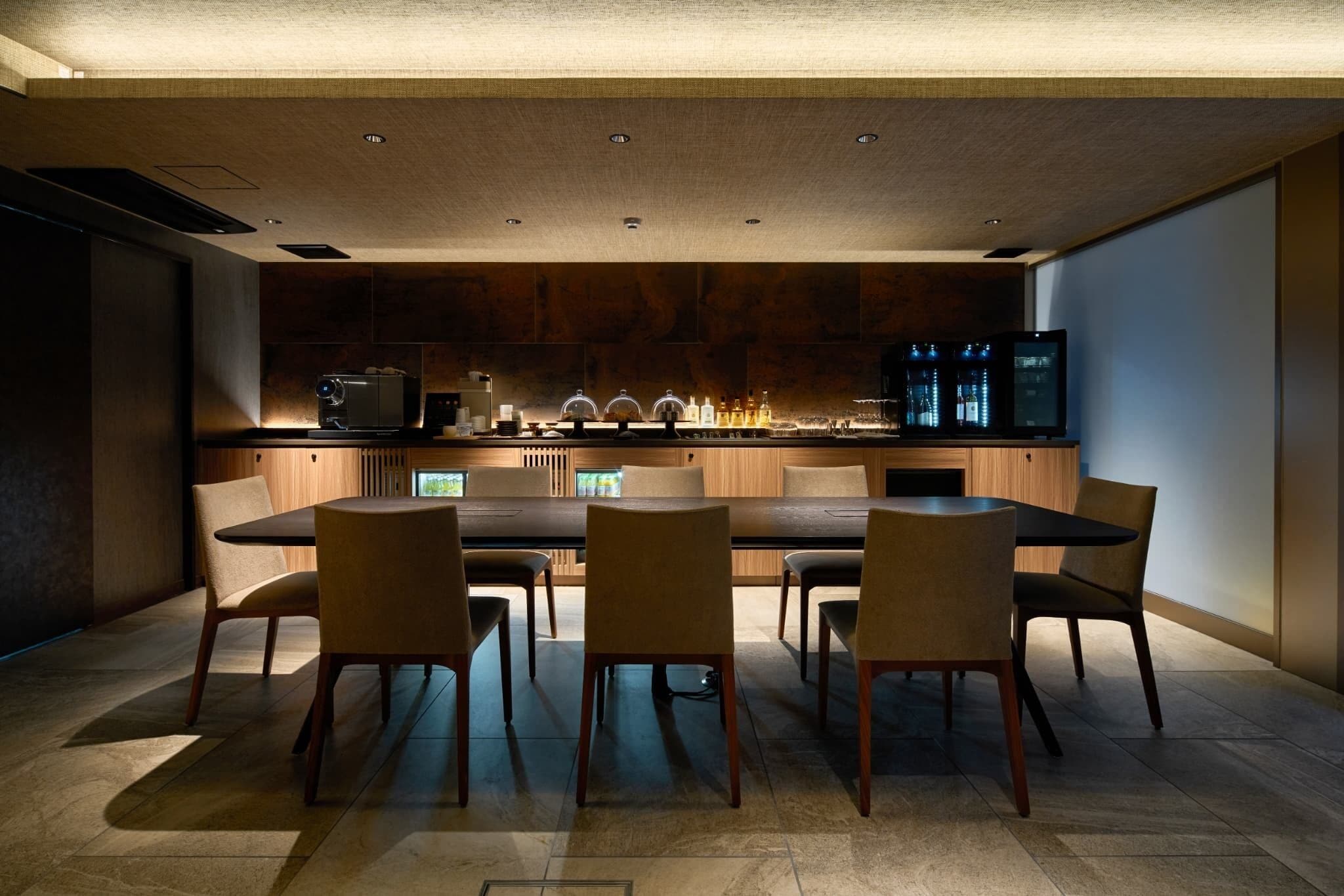 Una cocina moderna con comedor, armarios de madera, una mesa grande y un televisor.
