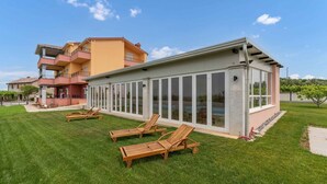 A modern building with large glass windows and a flat roof. - Holiday apartment mit Klimaanlage und Pool (Umag)