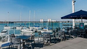 Un puerto deportivo con barcos, asientos al aire libre y vista al agua.