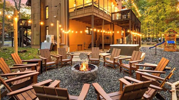 A wooden building with a fire pit and outdoor seating. - Unbelievable Poconos Estate - Hot Tub, Game Room (East Stroudsburg)