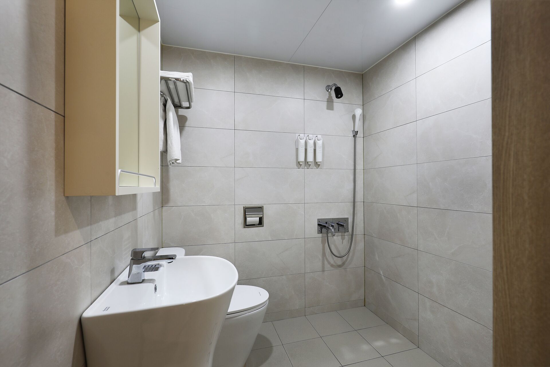 Un baño moderno con inodoro, lavamanos y ducha.