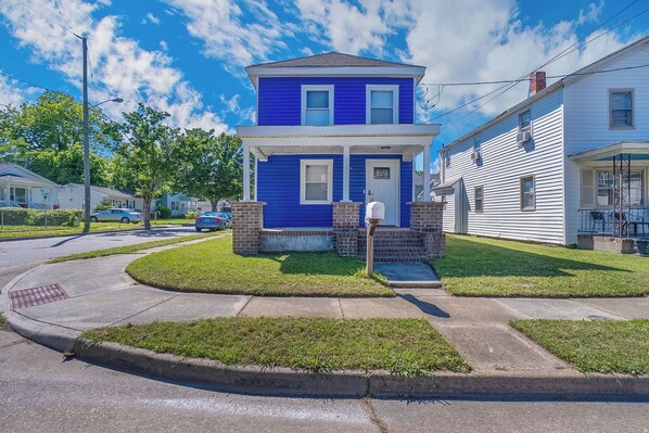 A two-story house with a front porch, a mailbox, and a well-maintained lawn.