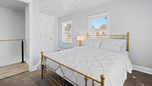 A bedroom with a bed, a ceiling fan, a window with blinds, and a door. - Cozy 4 Bed 2 Bath Home - Norfolk, Centrally Located (Norfolk)