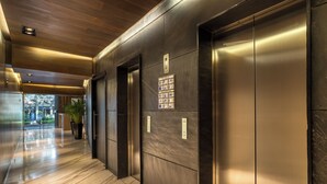 A modern elevator with a control panel, a polished marble floor, and a wooden ceiling. - Chic Barrio Living in Roma Norte - 2BR & Rooftop (Ciudad de México)