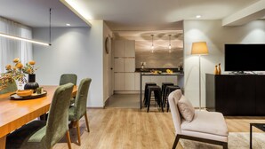A modern kitchen with a dining area, a sofa, and a TV. - Chic Barrio Living in Roma Norte - 2BR & Rooftop (Ciudad de México)