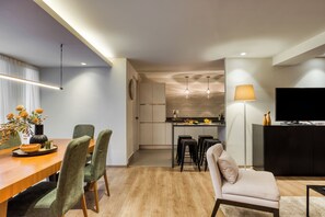 Eine moderne Küche mit Essbereich, einer Couch und einem Fernseher.