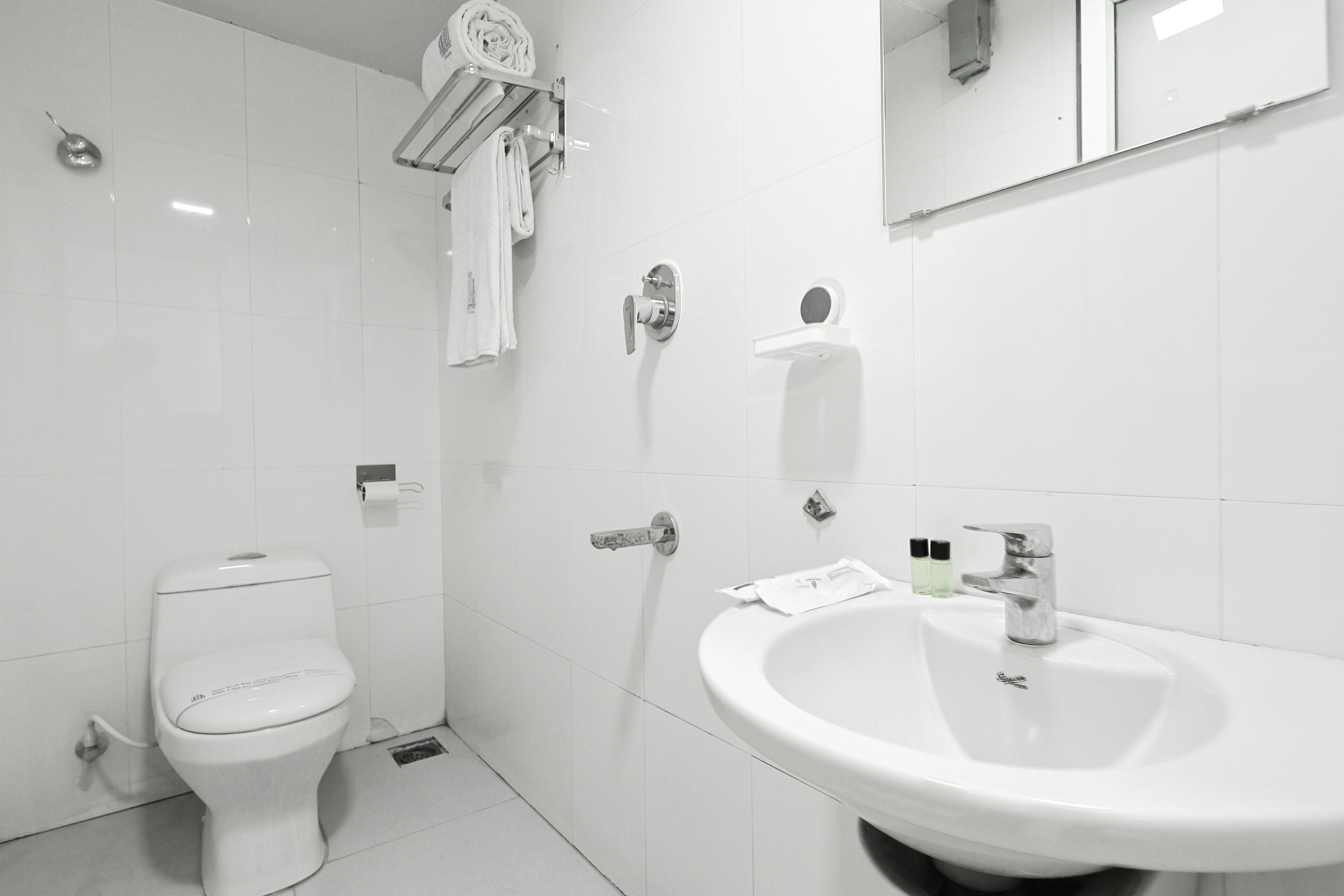 Un baño moderno con inodoro, lavabo y toallero.