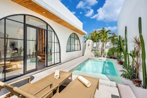 Un espace piscine moderne, doté de chaises longues et offrant une vue dégagée sur la piscine.