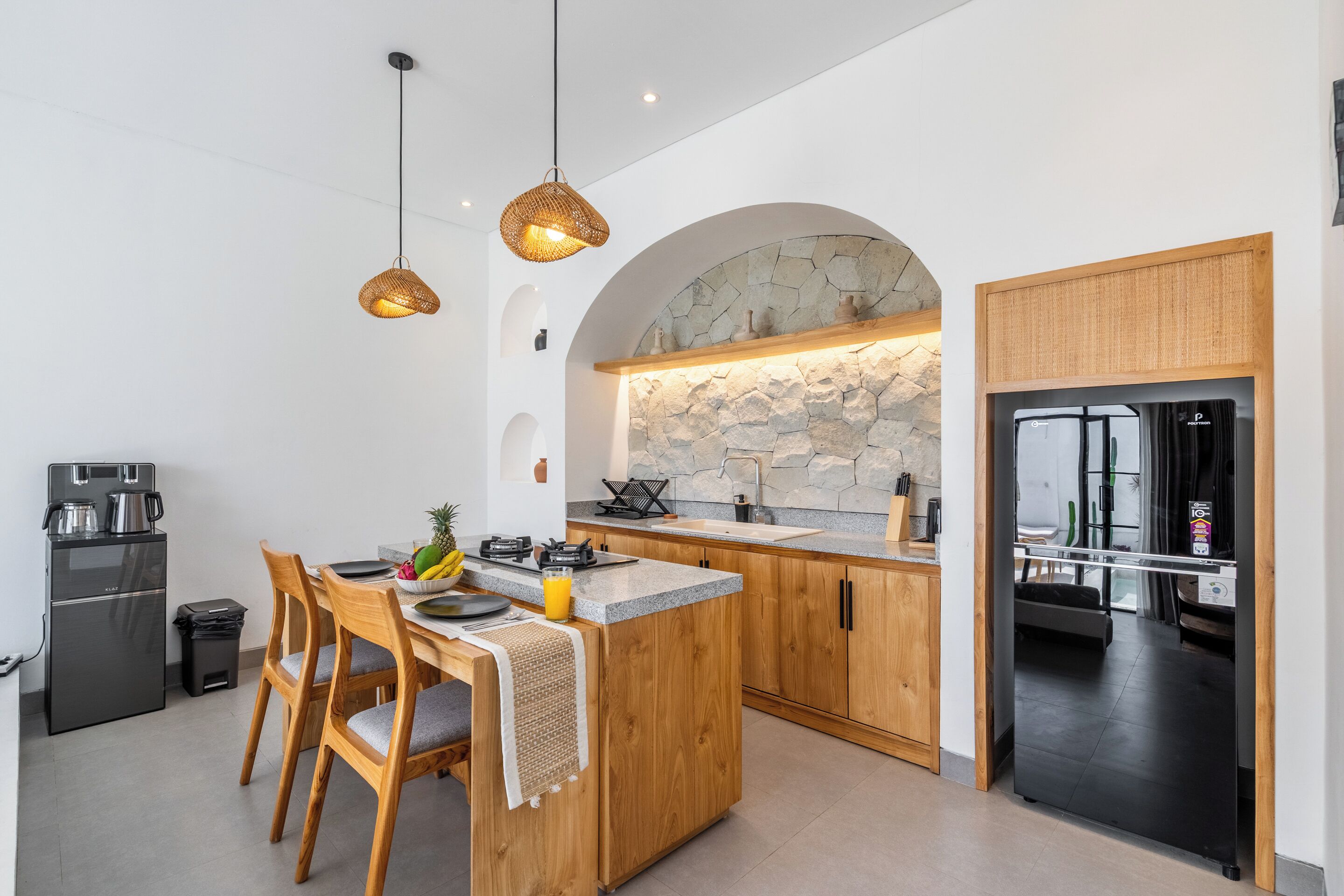 A modern kitchen with wooden cabinets, a stone backsplash, and a built-in island.