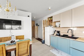 Eine moderne Küche mit Einbauherd, Spüle und Essbereich mit Tisch und Stühlen.