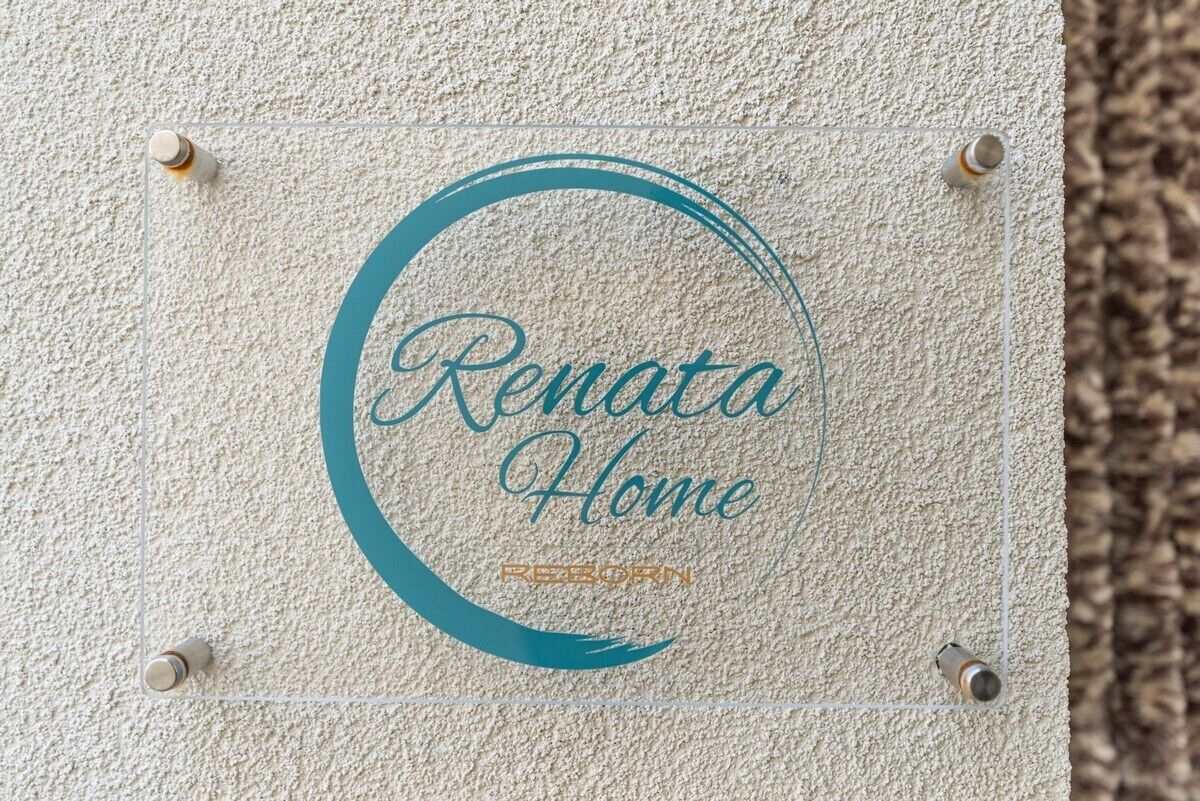 A textured wall with a circular logo and the text 'Renata Home' and 'REBORN' visible.