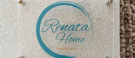 A textured wall with a circular logo and the text 'Renata Home' and 'REBORN' visible.