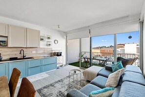 Eine moderne Wohnung mit Küche, Essbereich und einem Balkon mit Blick.