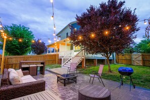 A backyard patio with outdoor furniture, a barbecue grill, and a staircase leading to a covered porch. - Spacious City Home I Fenced Backyard | Firepit (Richmond)