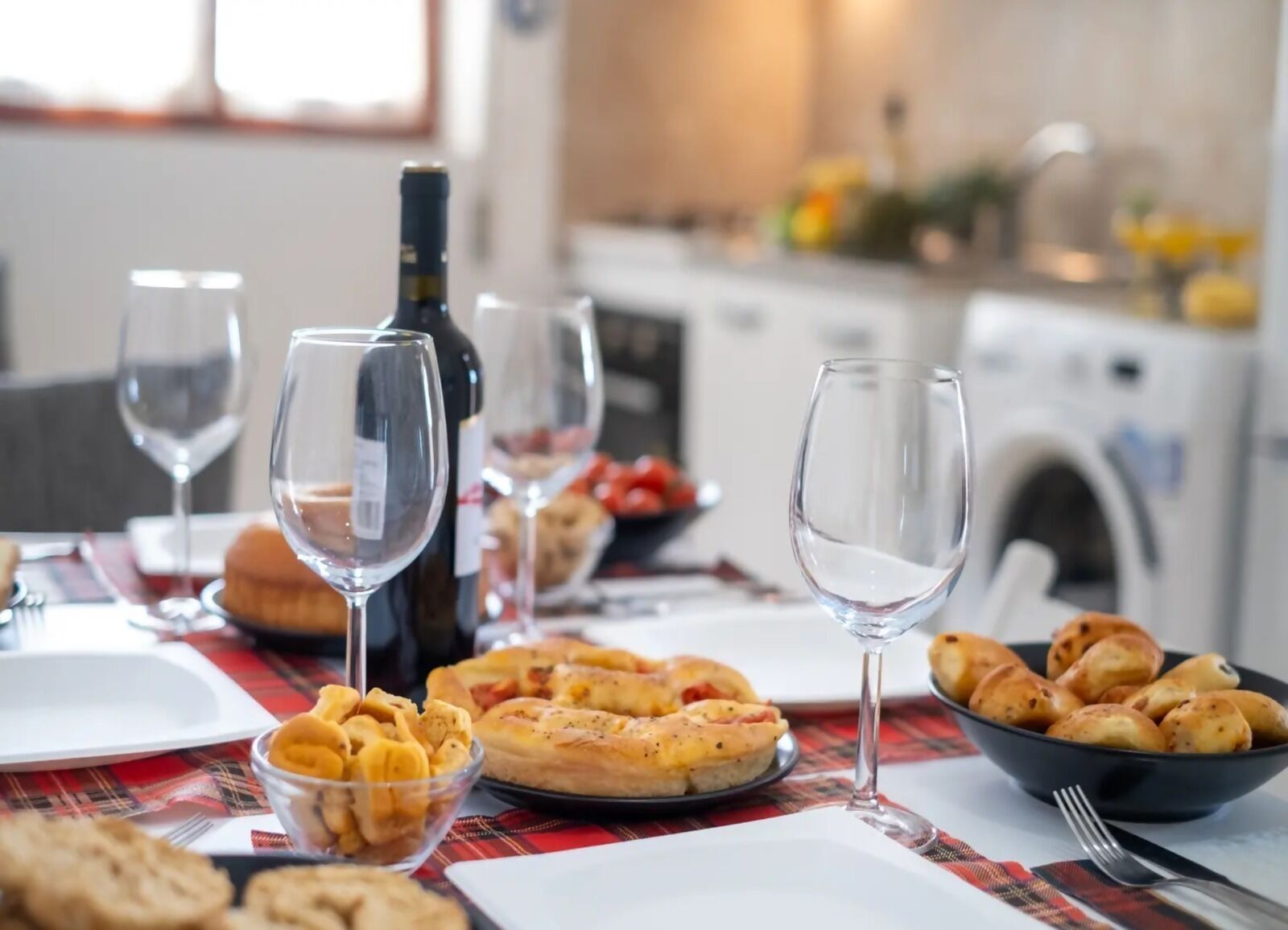 A dining table with wine glasses, a bottle, and various dishes.