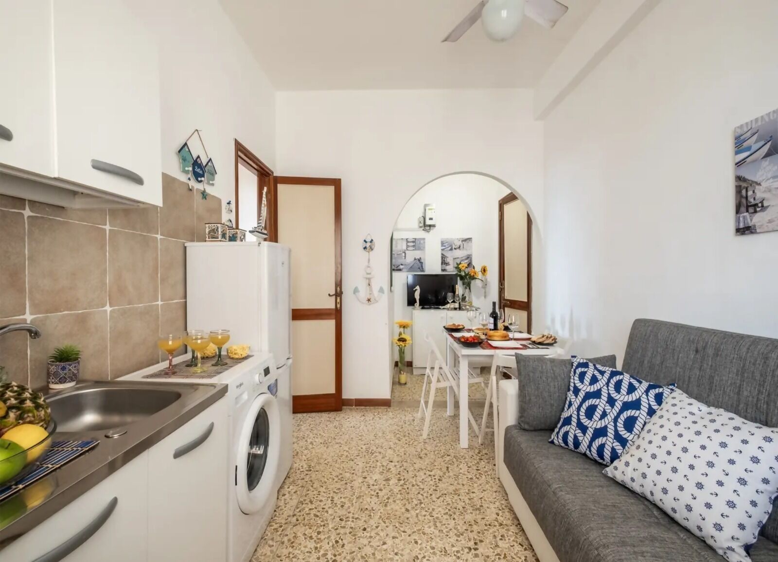 Een knus woongedeelte met een kitchenette, een eethoek en een bank.