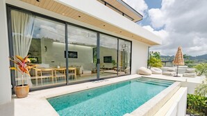 A modern house with a swimming pool, large glass doors, and a view of the landscape. - Aileen P3 V4 Saku Staycation (Sa Khu - Thalang)