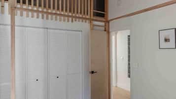 Un dormitorio con cama, ventilador de techo, techo de listones de madera y armario.