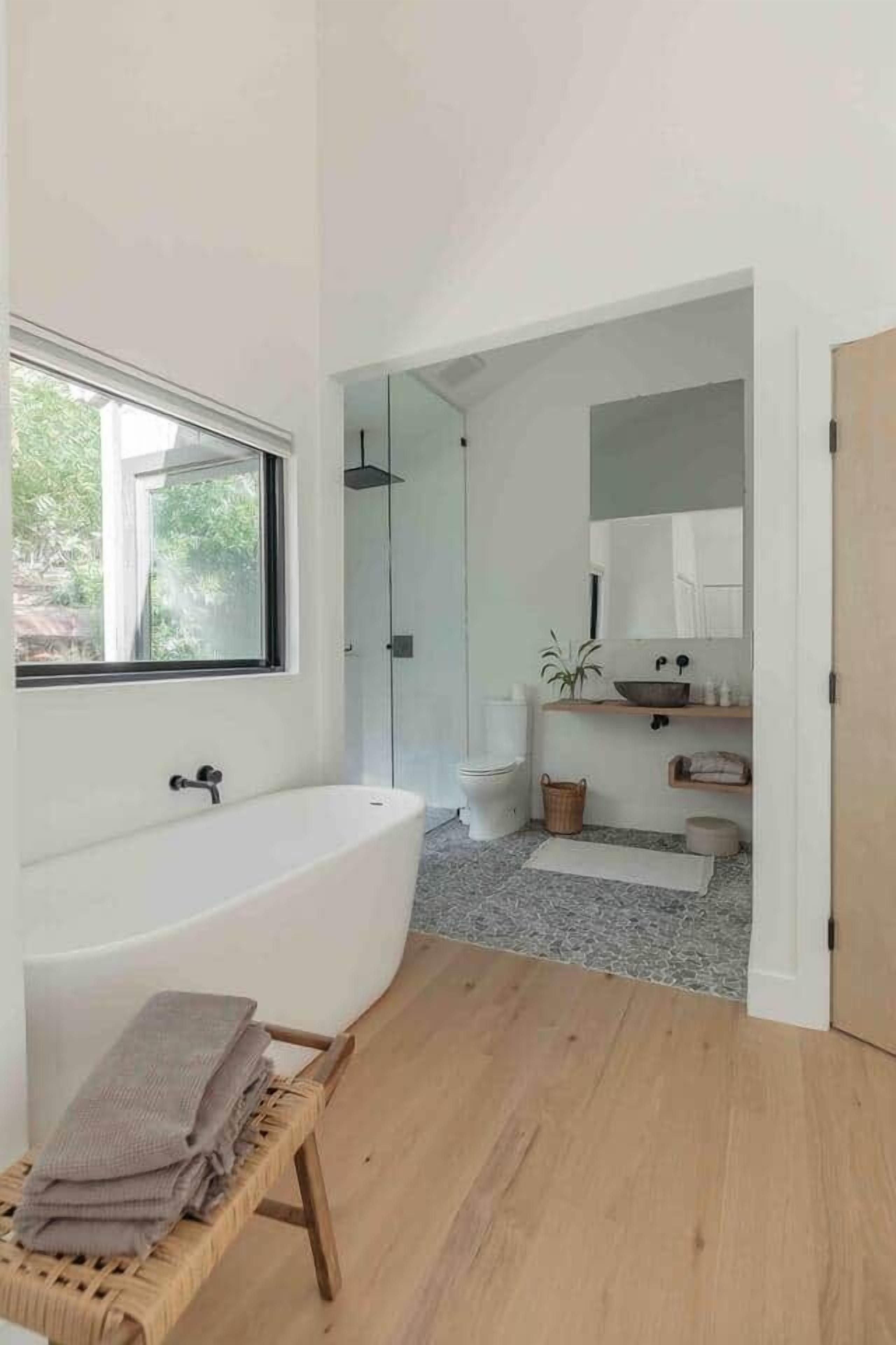 Ein modernes Badezimmer mit einer freistehenden Badewanne, einer Toilette und einem Waschbecken.