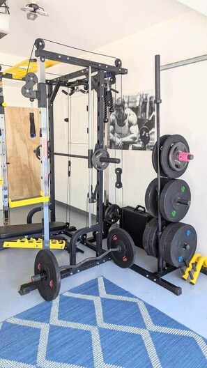 Een sportschool met een squatrek, een halter en gewichtsschijven.