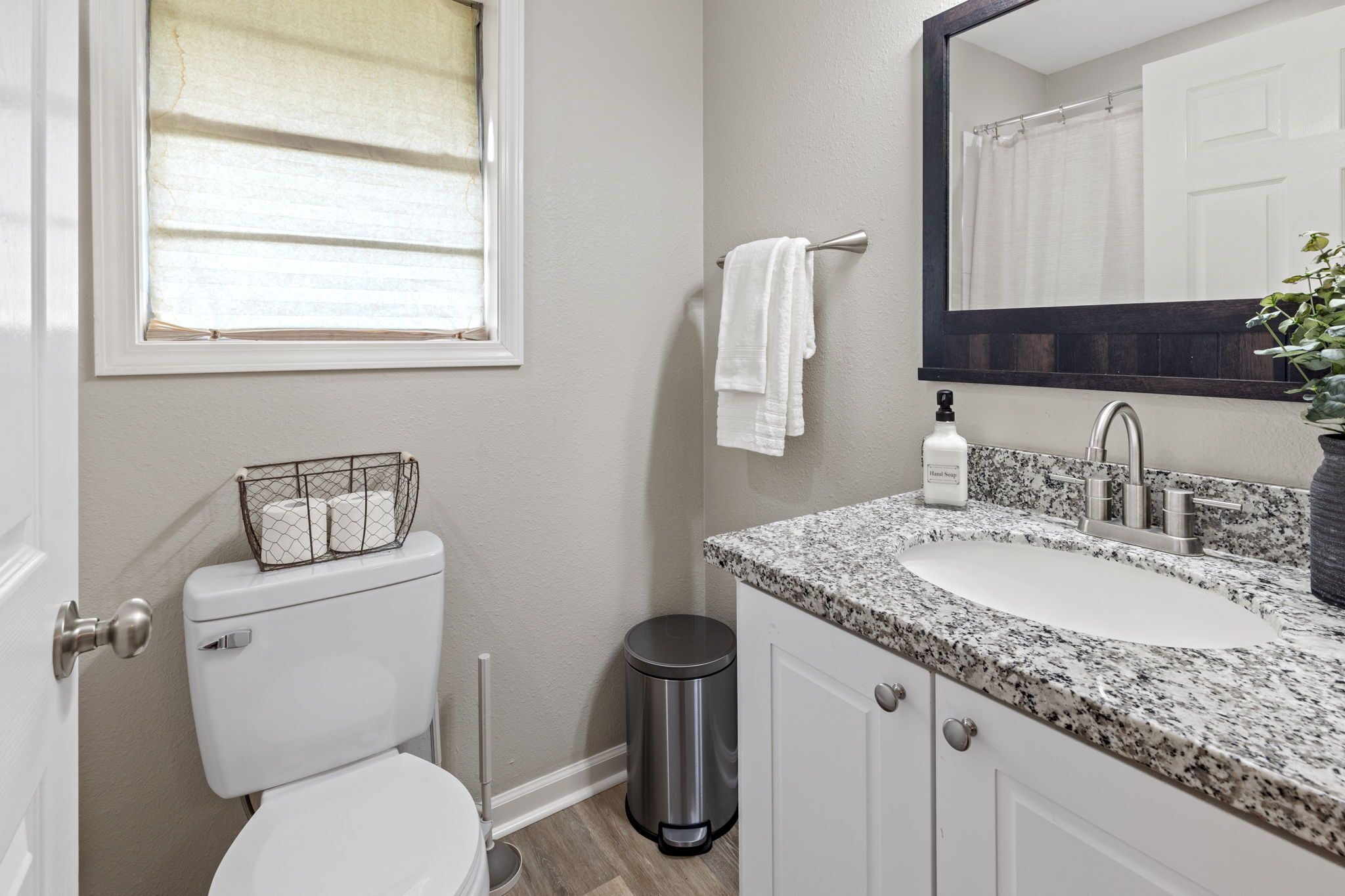 Une salle de bain avec des toilettes, un lavabo et un miroir.