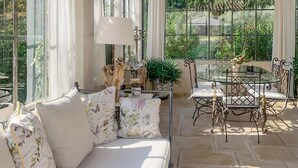 A sunlit room with a sofa, a table, and chairs, large windows, and a view of greenery outside. - Pet friendly home in Saint-Rémy-de-Provence (Saint-Rémy-de-Provence)