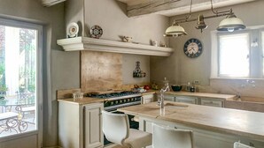 A kitchen with a central island, bar stools, a stove, and a clock on the wall. - Pet friendly home in Saint-Rémy-de-Provence (Saint-Rémy-de-Provence)