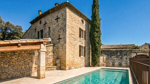 A stone building with a pool, a pergola, and a tall tree. - Maison avec piscine privée (Clansayes)