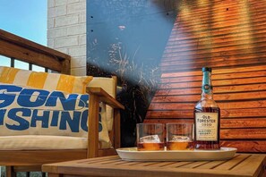 A wooden table with a bottle of Old Forester 1910 whiskey and two glasses on a tray. - Creekside, walk to Landing and convention center (Branson)