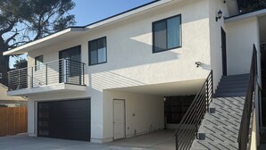 A two-story house with a garage, a balcony, and a staircase. - Perfect 2-bedroom corporate apartment with AC in peaceful Altadena (Altadena)