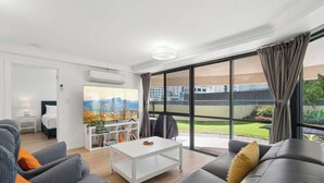 Een moderne woonkamer met een flatscreen televisie, een salontafel en een bank.