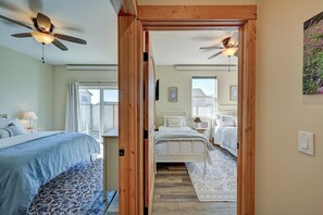 A bedroom with a bed, bedside table, lamp, and a window with curtains. - Cloud Cottage | Parkside • Pet Friendly • STR 334 (Buena Vista)