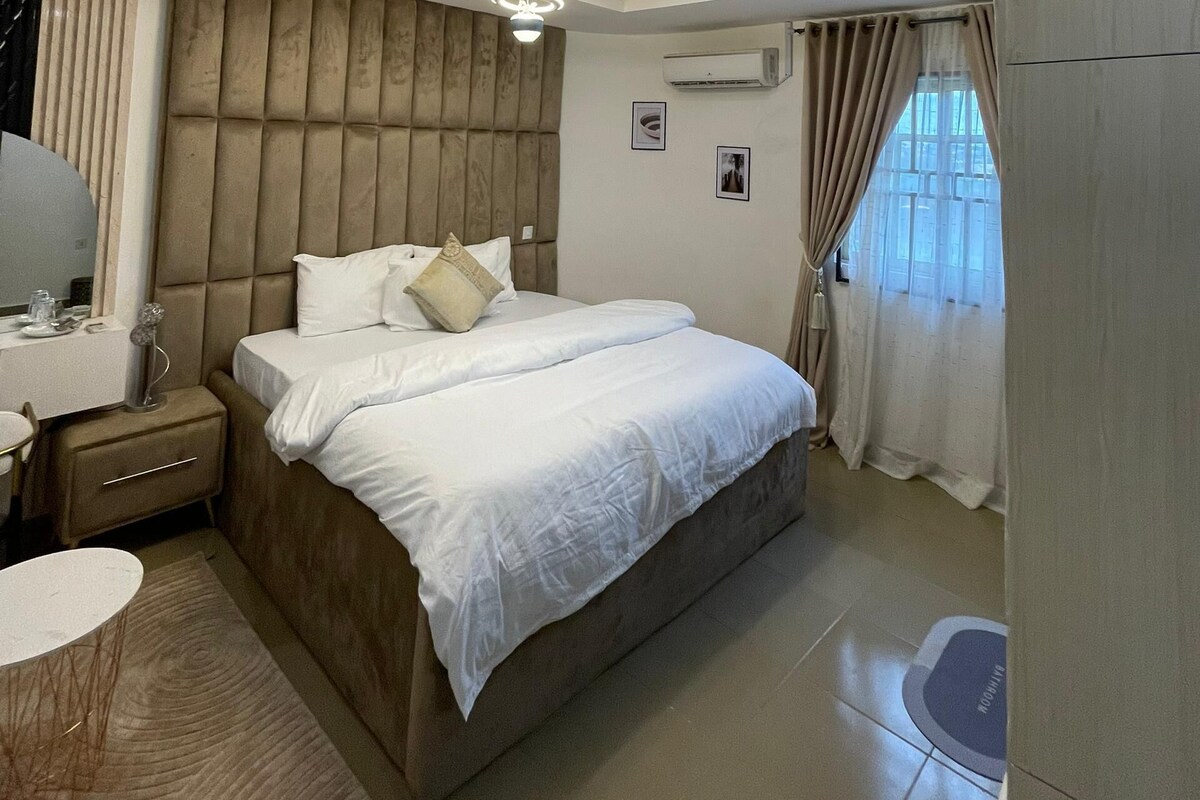 Une chambre moderne avec un grand lit, des tables de chevet, un bureau et une armoire.