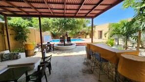 An outdoor patio area with a pool, seating, and a covered bar. - Casa Bustani Tierra Bomba Island - Bocachica (Bocachica)