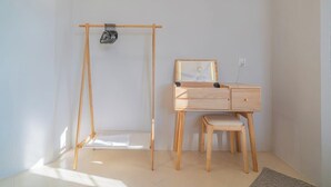 Una habitación minimalista con un escritorio de madera, una silla pequeña y un columpio de madera.