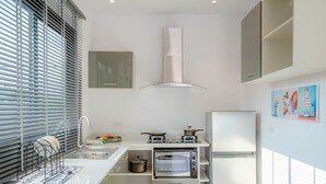 Een moderne keuken met een ingebouwde oven, een koelkast en een fornuis.