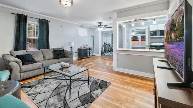 Ein modernes Wohnzimmer mit Sofa, Couchtisch und Fernseher.