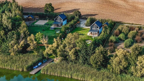 A large property with multiple houses, a dock, and a pond.