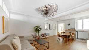 A modern living room with a sofa, coffee table, dining area, and kitchen. - So Chic Montorgueil Paris (Paris)