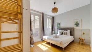 A bedroom with a bed, a wooden wardrobe, a fan, and a window. - So Chic Montorgueil Paris (Paris)