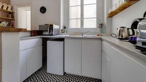 Une cuisine compacte équipée d’un four à micro-ondes, d’un évier et d’une machine à café.