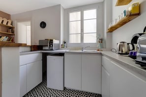 A compact kitchen with a microwave, sink, and coffee maker. - So Chic Montorgueil Beauty (Paris)