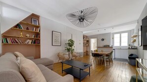 Un salon moderne avec un canapé, une table basse et des étagères.