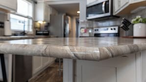 Una cocina con gabinetes blancos, un refrigerador de acero inoxidable y un microondas.