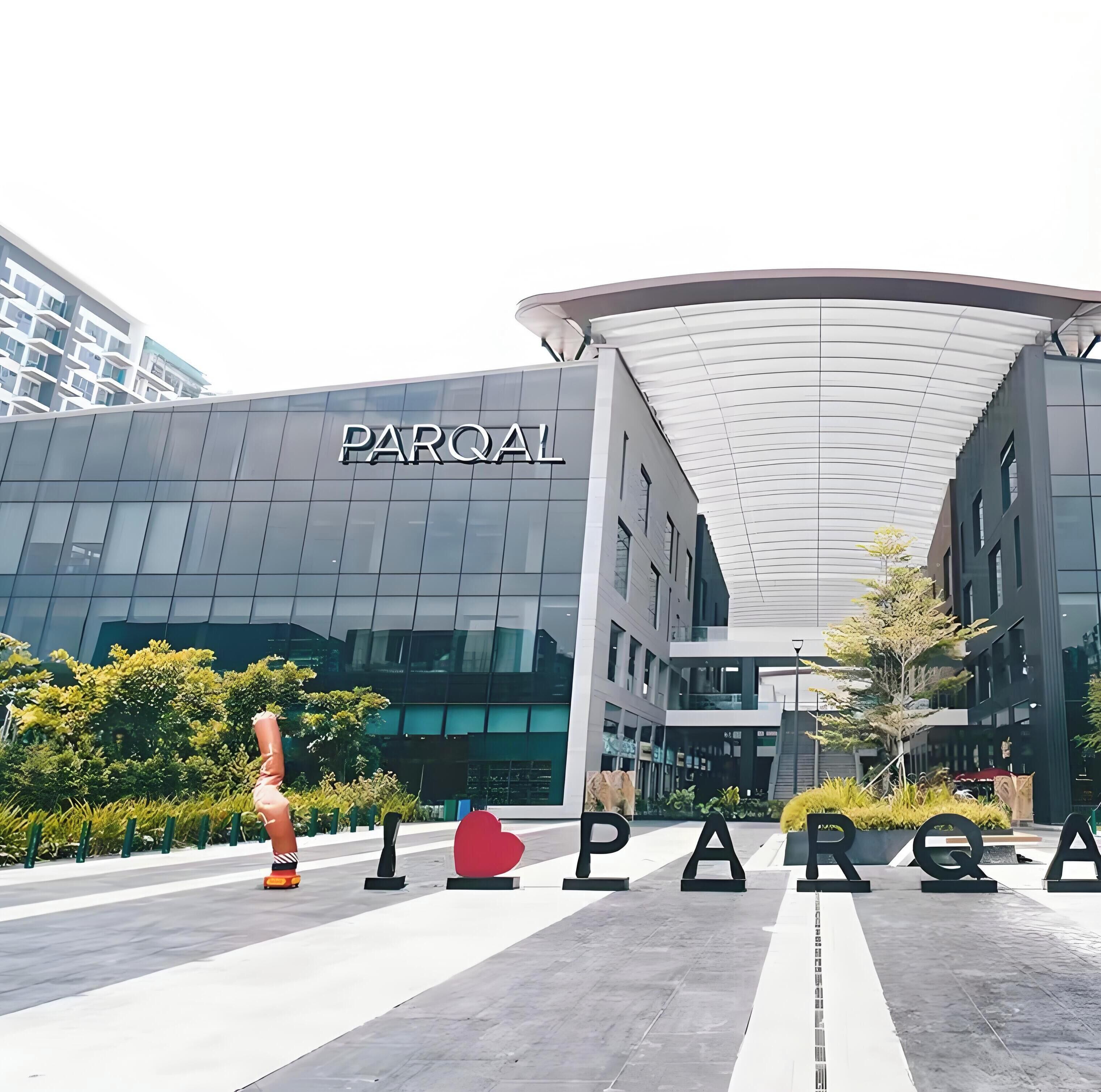 A modern building with a curved roof and the sign 'PARQAL' on the facade.