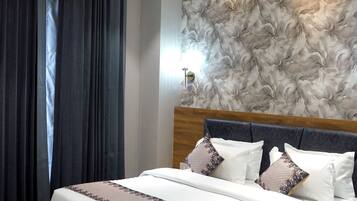 Un dormitorio moderno con una cama de madera, un ventilador de techo y una pared con textura.